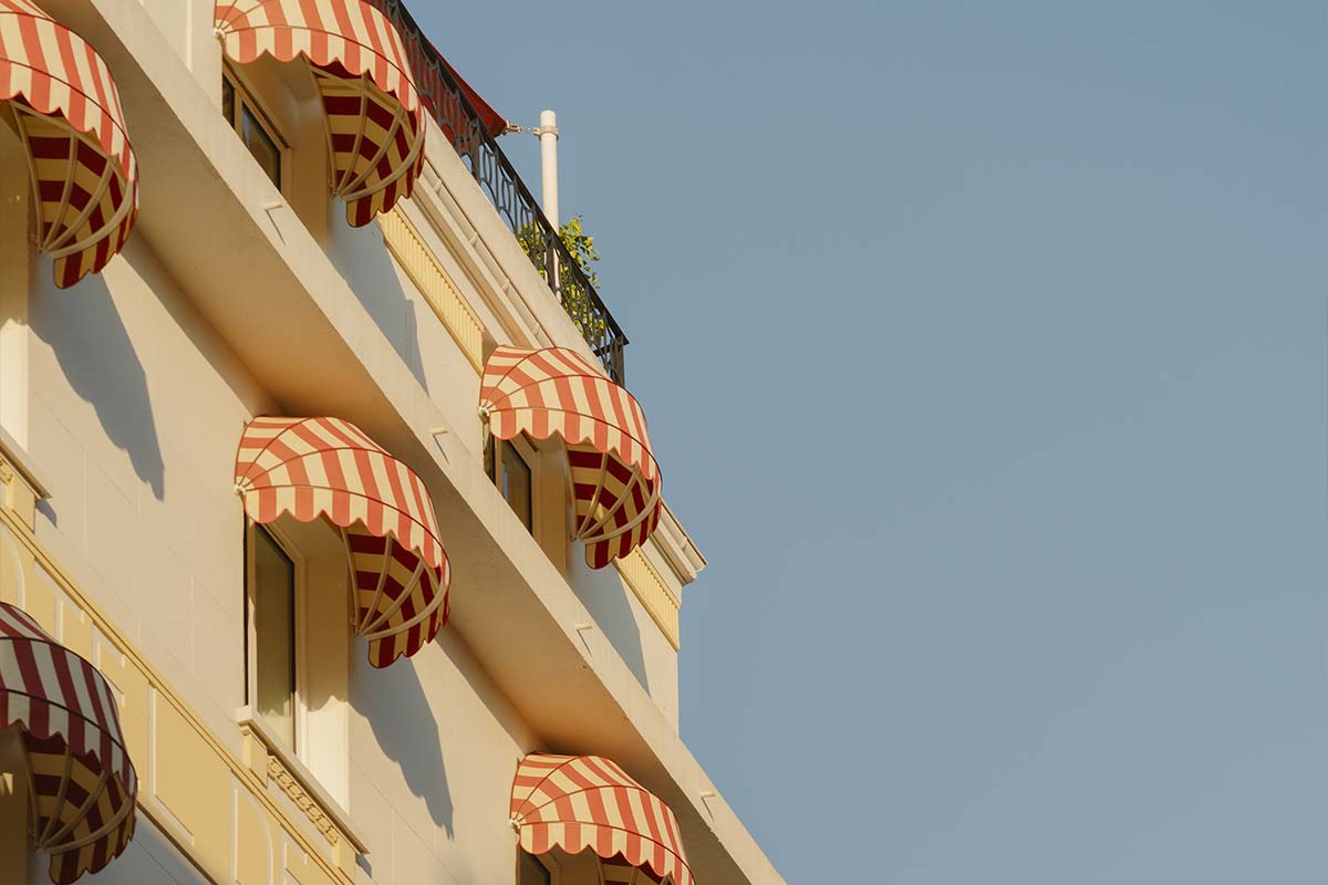 Façade de l’hôtel Edgar Suites à Cannes avec marquises rayées typiques de l’architecture méditerranéenne