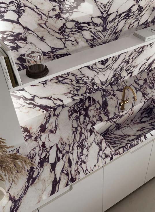 Surface en marbre veiné pour architecture intérieure contemporaine Plan vasque et crédence en marbre veiné violet créant une signature esthétique forte dans un espace contemporain