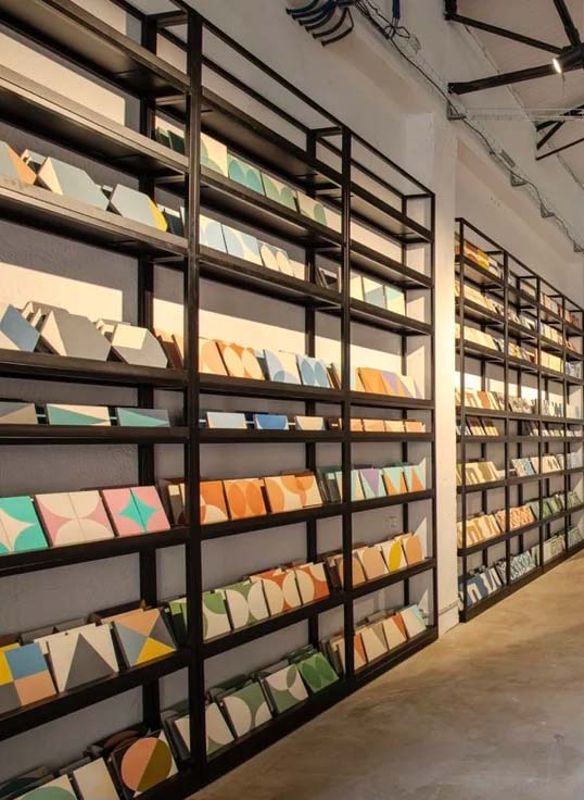 Sélection technique de carreaux pour projets architecturaux Mur de présentation de carreaux dans un showroom illustrant le choix technique et la coordination des matériaux pour projets architecturaux