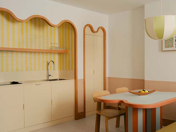 Cuisine et espace intérieur d’une suite de l’hôtel Edgar Suites à Cannes avec décor rayé pastel