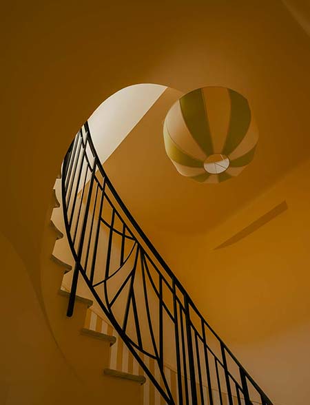 Escalier intérieur de l’hôtel Edgar Suites à Cannes avec architecture graphique et lumière chaude