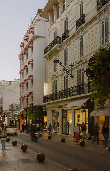 Salle de bain de l’hôtel Edgar Suites à Cannes avec carrelage rayé et miroir décoratif