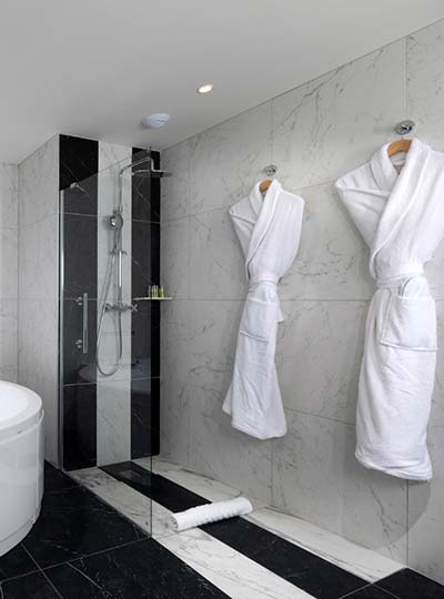 Douche et carrelage noir et blanc dans une salle de bain de l’Hôtel du Roi à Carcassonne