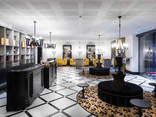 Lobby de l’Hôtel du Roi à Carcassonne avec carrelage noir et blanc graphique structurant l’espace d’accueil