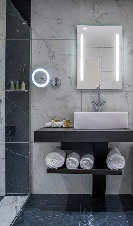 Salle de bain avec vasque et carrelage céramique effet marbre à l’Hôtel du Roi à Carcassonne