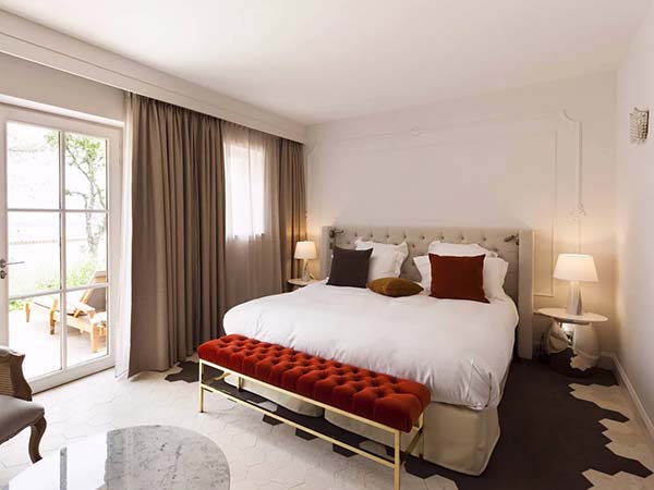 Jonction entre pierre naturelle et grès cérame en carrelage hexagonal dans une chambre d’hôtel au Mas des Herbes Blanches