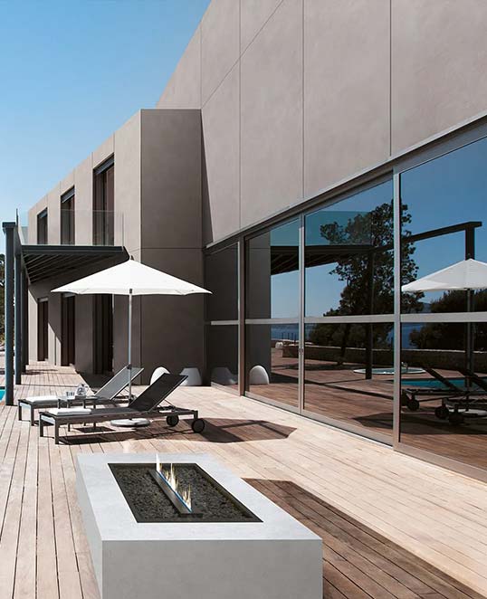 Dalles céramiques XXL effet béton en façade contemporaine avec terrasse minimaliste et continuité architecturale des surfaces