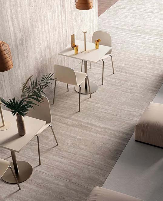 Sol intérieur en dalles céramiques XXL effet minéral clair dans un espace de restauration contemporain lumineux et épuré