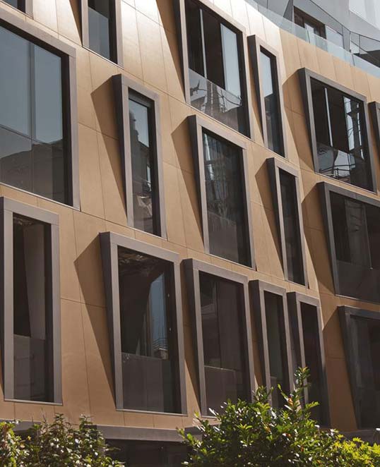 Pose collée de carrelage céramique en façade contemporaine Façade moderne avec carrelage posé collé sur support maçonné, panneaux céramiques grand format et modénature architecturale