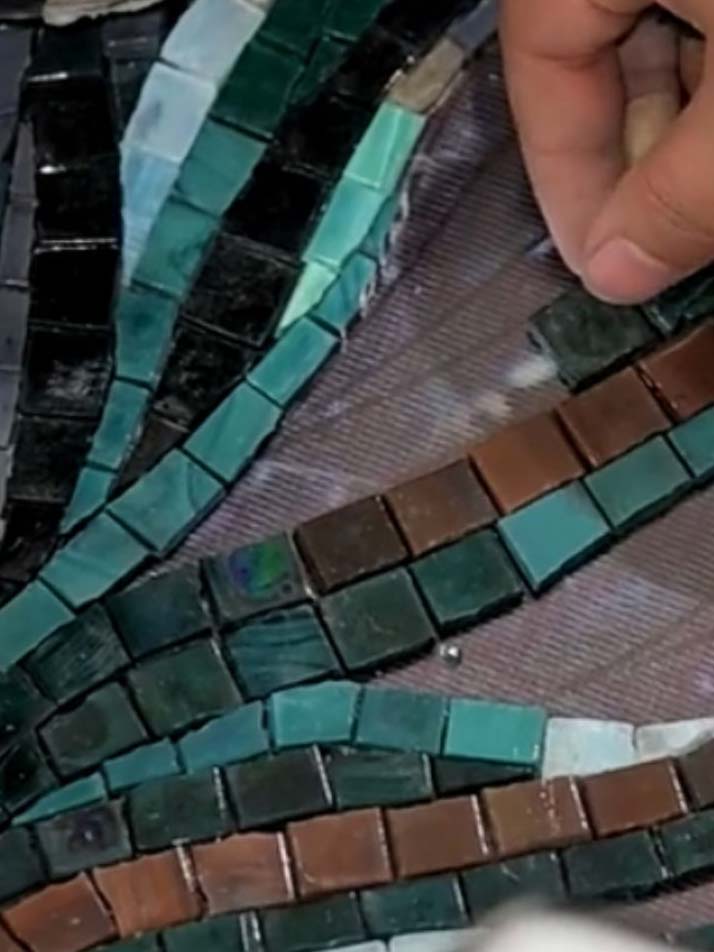 Pose artisanale de mosaïque sur mesure Pose manuelle de tesselles de mosaïque sur mesure illustrant la précision artisanale et la liberté de création décorative