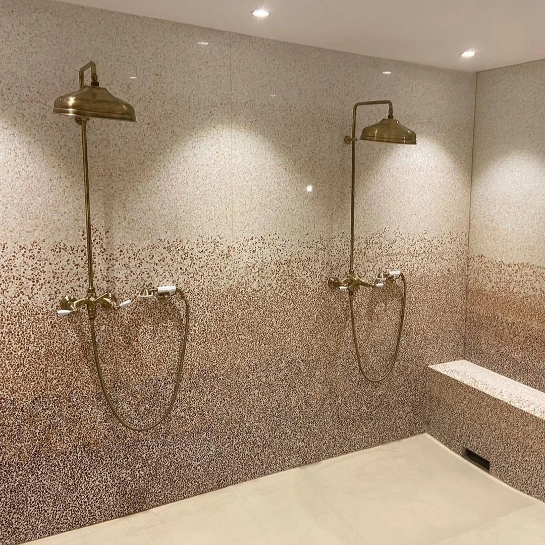 Revêtement terrazzo pour douche et hammam Douche et murs revêtus de terrazzo minéral beige créant une ambiance chaleureuse et durable