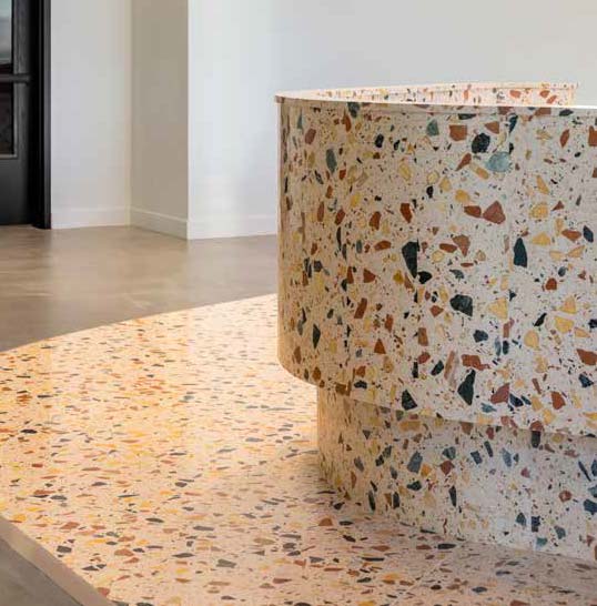 Terrazzo minéral entre tradition artisanale et architecture contemporaine Sol et mobilier en terrazzo minéral aux éclats de pierre dans une architecture intérieure contemporaine
