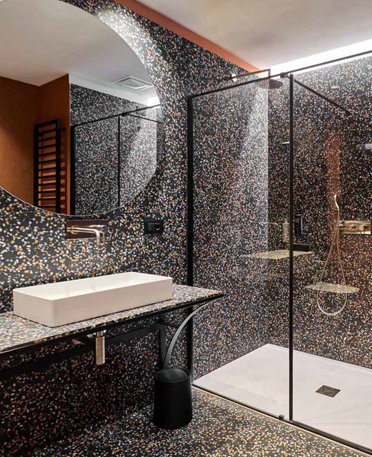 Effet métal en dalles XXL pour un style contemporain et contrasté Dalles céramiques XXL effet métal autour d’une cheminée contemporaine avec texture oxydée et ambiance architecturale chaleureuse