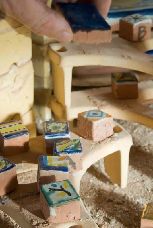 Traitement artisanal révélant la beauté de la terre cuite Application manuelle de finition sur carreaux en terre cuite décorés illustrant le traitement artisanal de surface